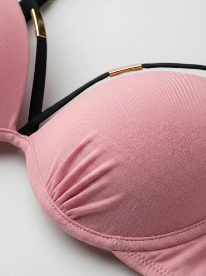 Nahaufnahme des hellrosa Bikini-Oberteils mit gerafftem Stoff und goldfarbenem Zierelement