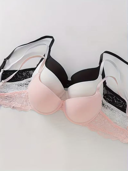 3er Set Damen Bügel BHs in Rosa, Weiß und Schwarz dekorativ präsentiert