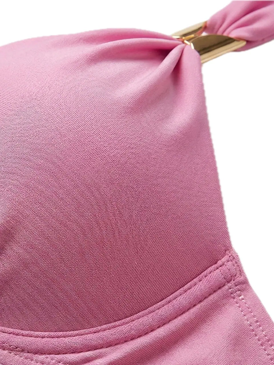 Detailaufnahme des weichen rosa Carvico-Bikini-Materials mit Naht und goldfarbenem Zierelement