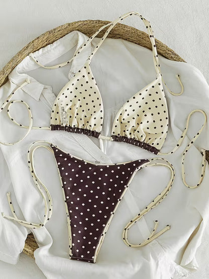 Brauner Polka Dot Bikini als Flatlay mit cremefarbenem Triangel-Oberteil und seitlich gebundener Hose